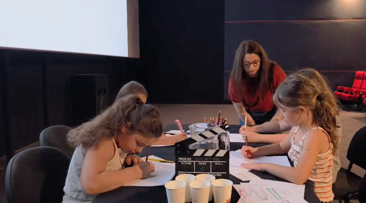 Marlène accompagne des enfants pendant un atelier Velvet Fox dans une salle de cinéma